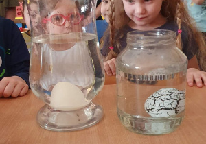 Dziewczynka obserwuje jajo dinozaura