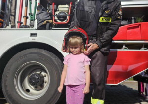 Strażak zakładający kask dziewczynce
