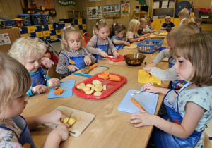 grupa dzieci kroi warzywa i owoce