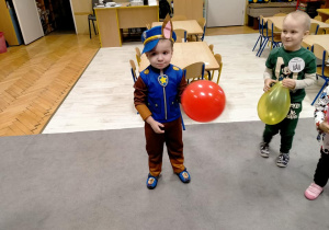 Chłopiec w stroju pieska z balonikiem.