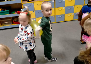 Dzieci tańczą z balonami między plecami.