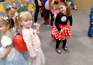 Dzieci tańczą z balonami między plecami.