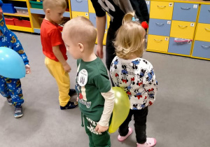 Dzieci tańczą z balonami między pupami.