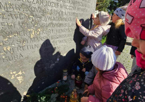 dzieci oglądają pomnik stu straconych