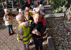 dzieci stoją na cmentarzu
