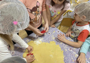 Przedszkolaki wykrawają ciasteczka.