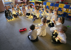 Dzieci siedzą ze światełkami