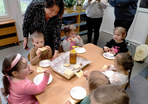 Dzieci jedzą wafle z miodem.